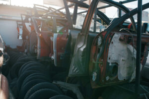 Car parts and tires on junkyard, nobody. Auto scrap, vehicle junk, automobile garbage. Abandoned, damaged and crushed transport, scrapyard